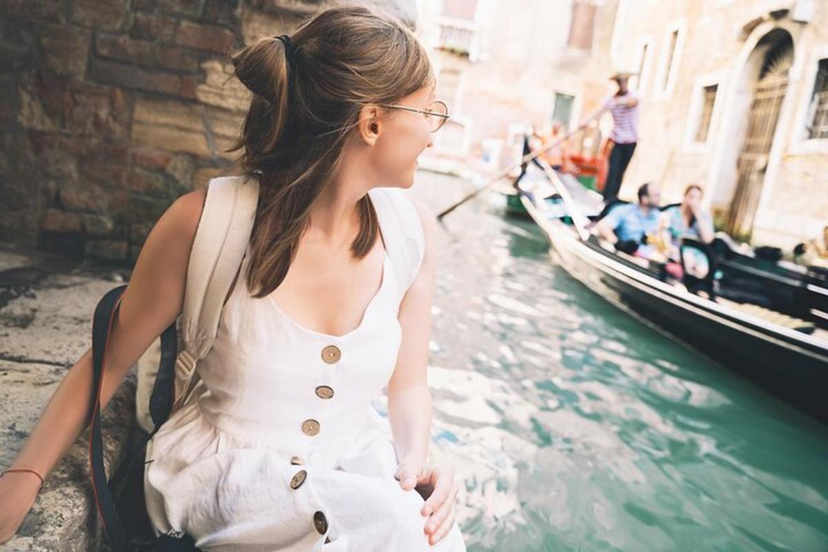 una donna in abito bianco in piedi accanto a un canale