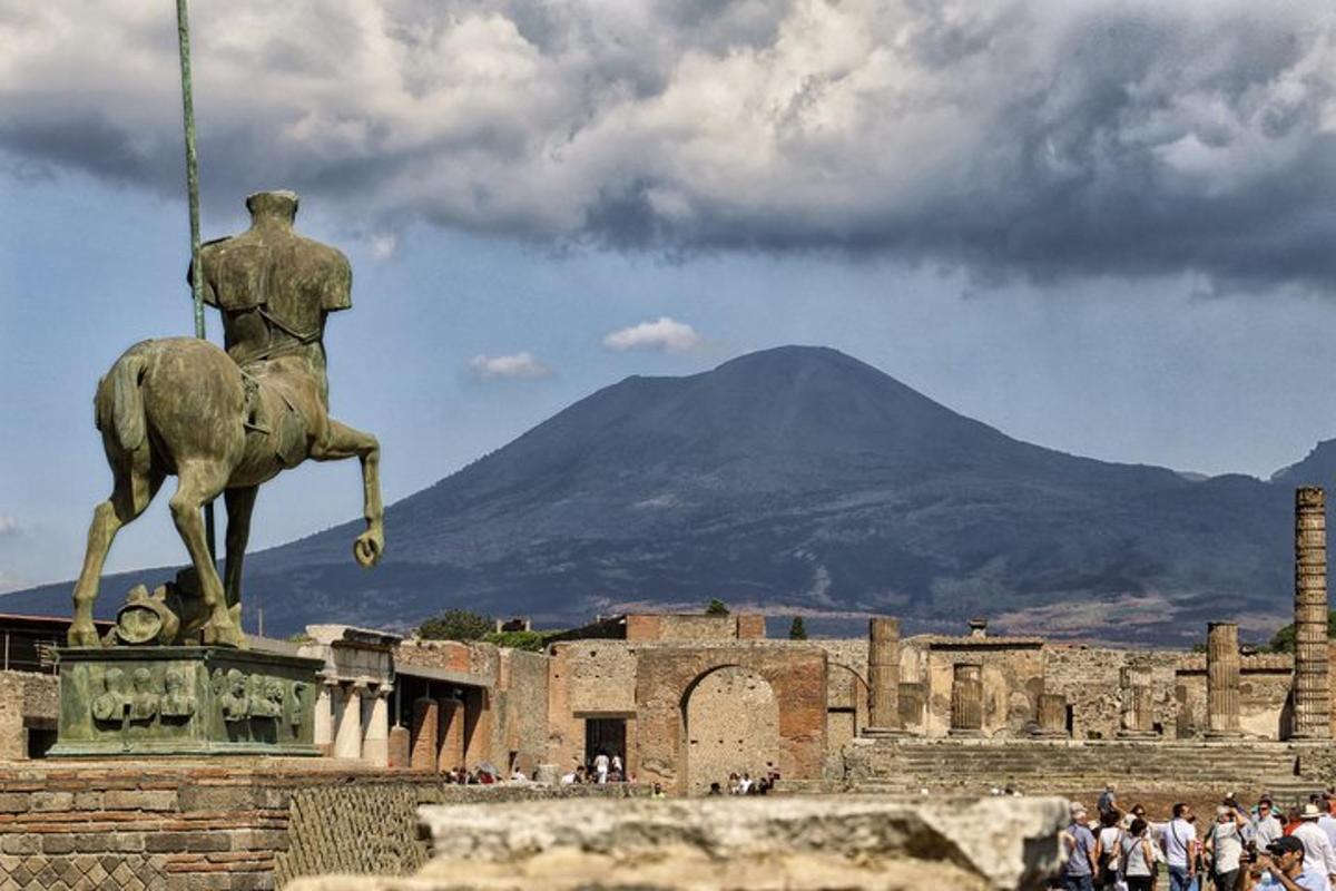 a statue of a man riding a horse with a mountain in the background