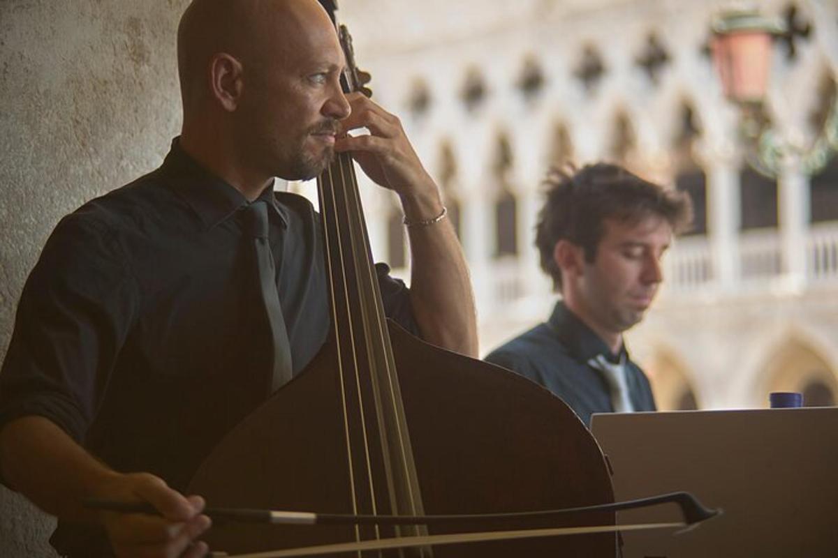 un uomo che suona il violoncello mentre un altro uomo guarda