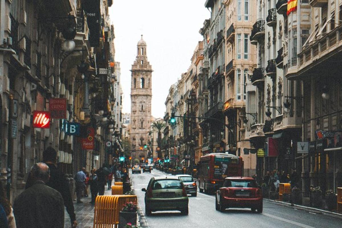 a busy city street with cars and a clock tower