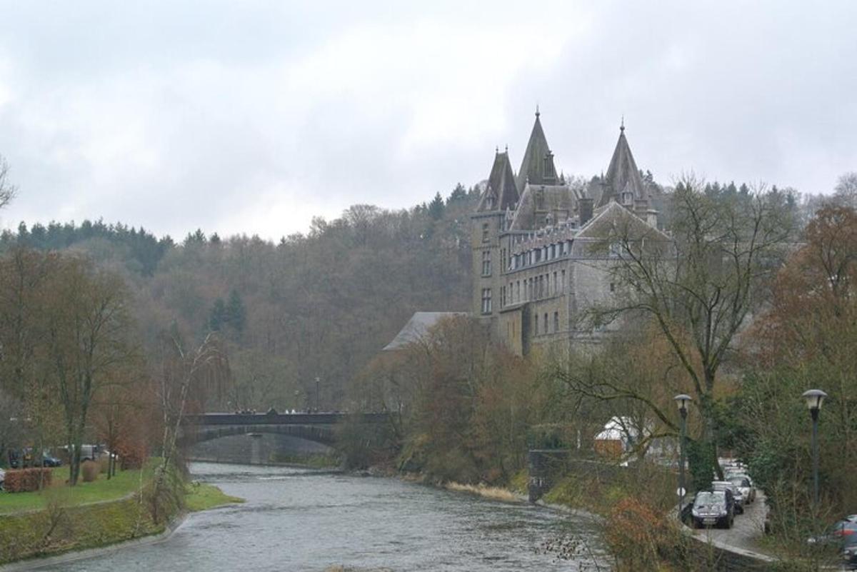 un grande edificio accanto a un fiume con un ponte