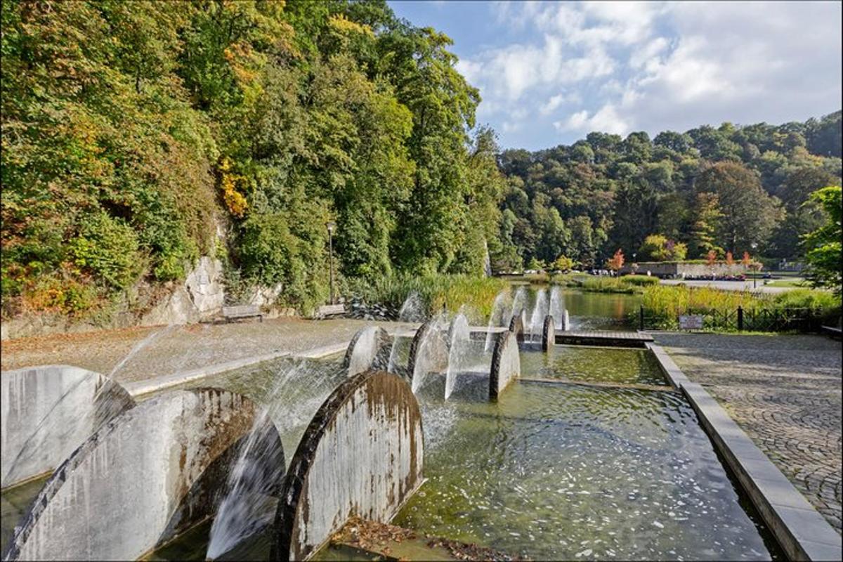 una fontana d'acqua in un fiume con alberi sullo sfondo