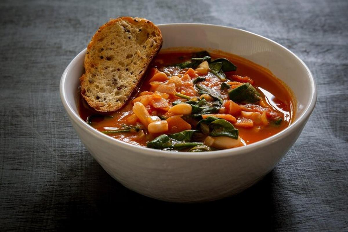 una ciotola di zuppa con un pezzo di pane dentro