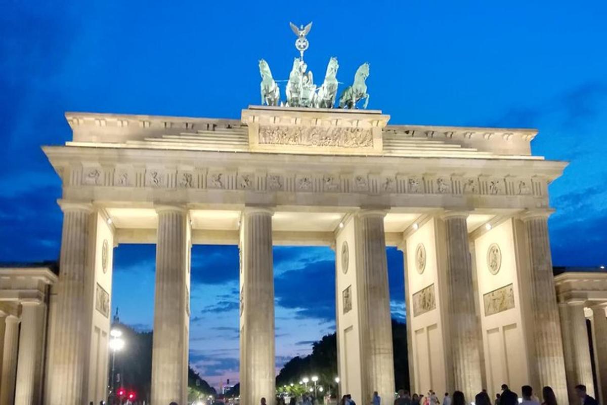 Un gran monumento con gente caminando delante.
