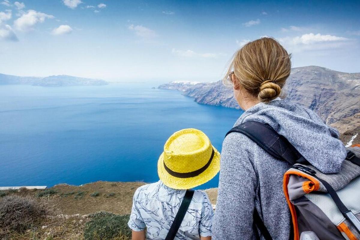 una dona i un nen drets dalt d'un turó mirant l'oceà