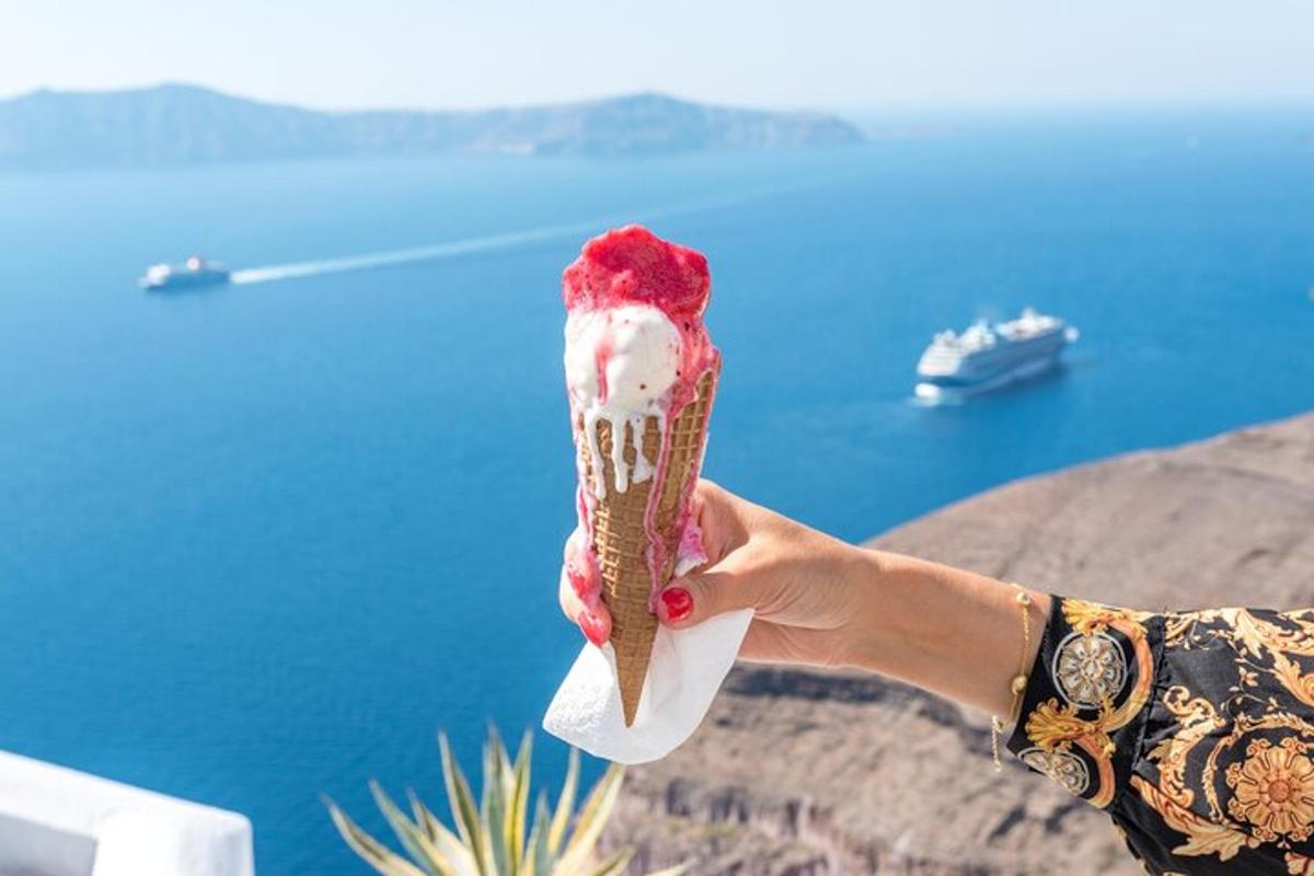 una mà sostenint un con de gelat amb vistes a l'oceà