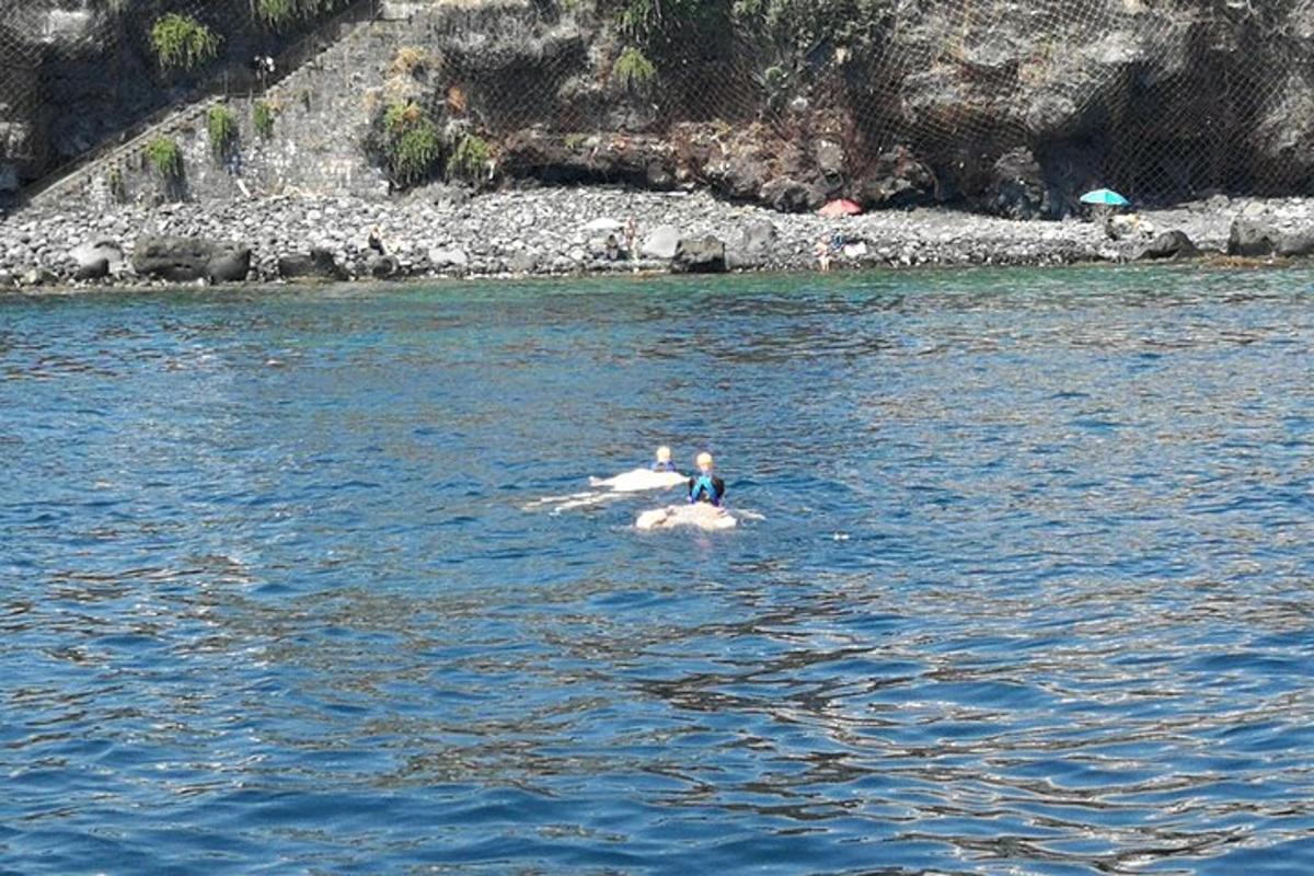 dua orang sedang berenang di dalam badan air