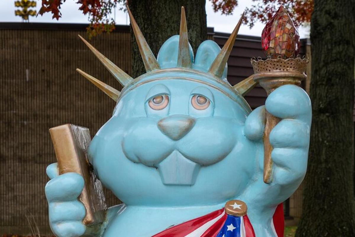 a statue of a blue cat holding a flag