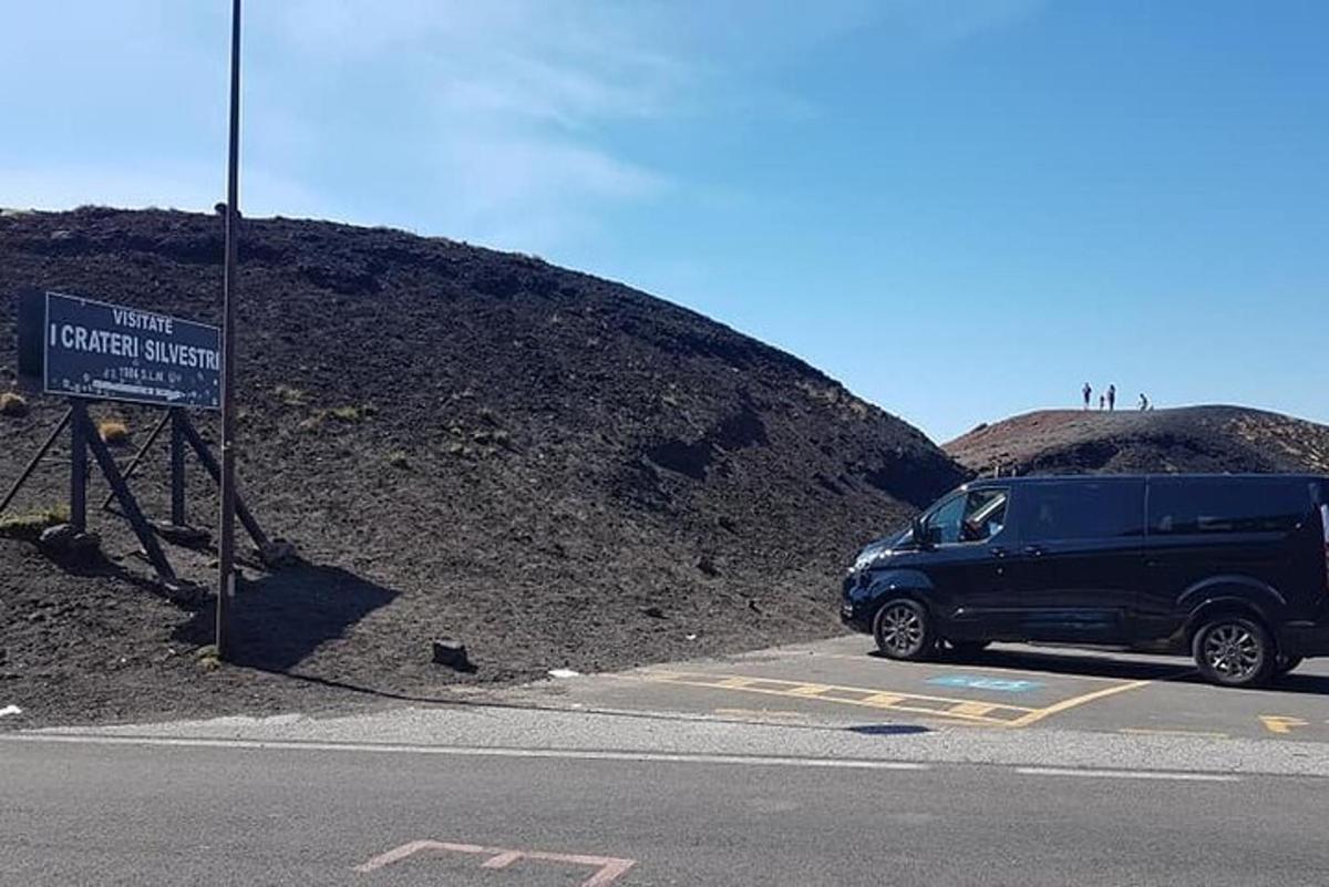 en blå lastbil parkeret ved siden af et skilt på en bakke