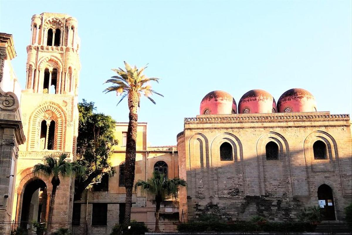 un vecchio edificio con una palma e una torre