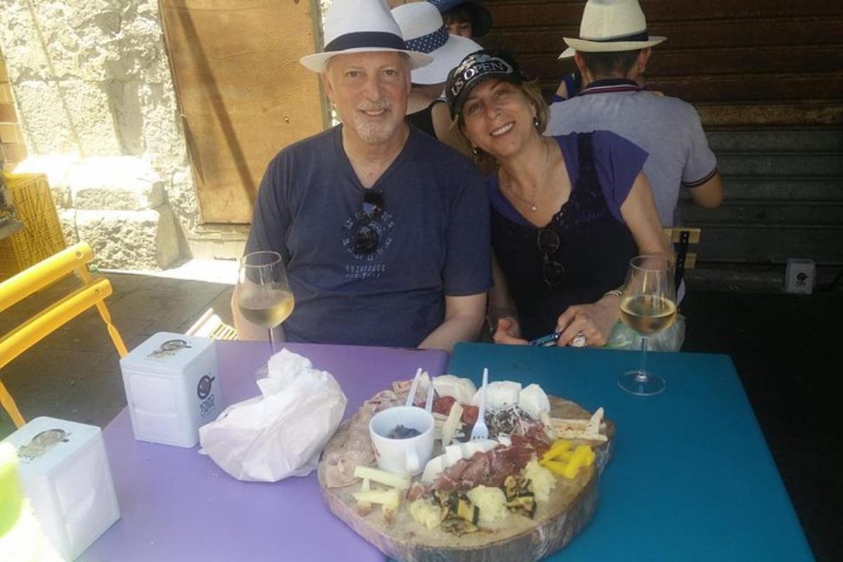 Un hombre y una mujer sentados en una mesa con un plato de comida.