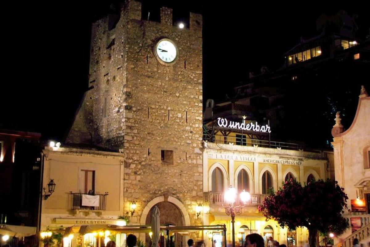 un grande edificio con una torre dell'orologio di notte