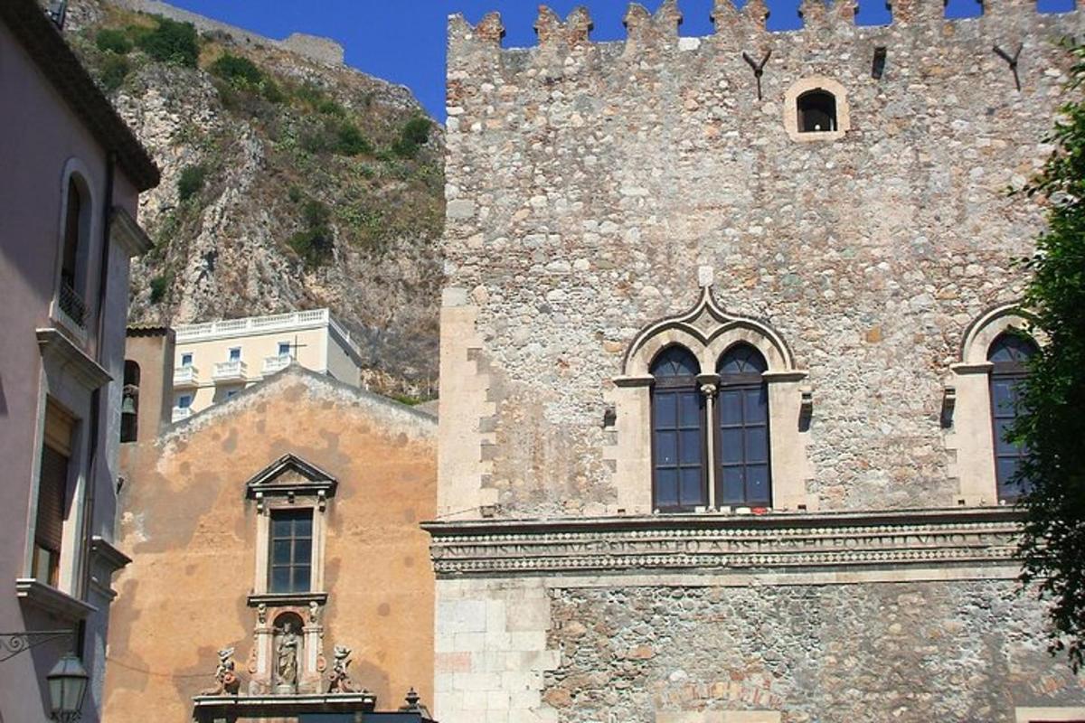 un grande edificio in pietra con una torre e un castello