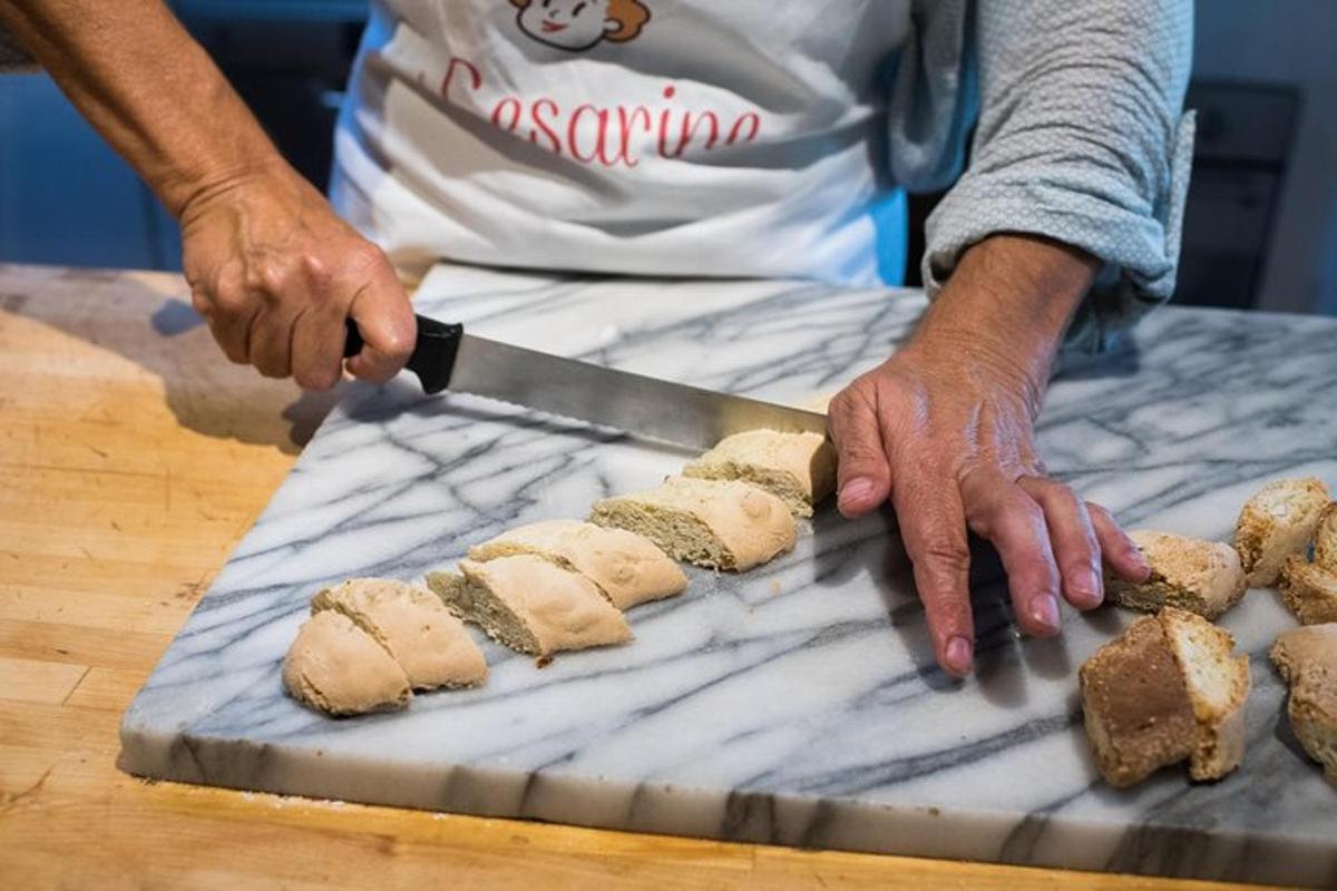 henkilö leikkaa leipää veitsellä leikkuulaudalla