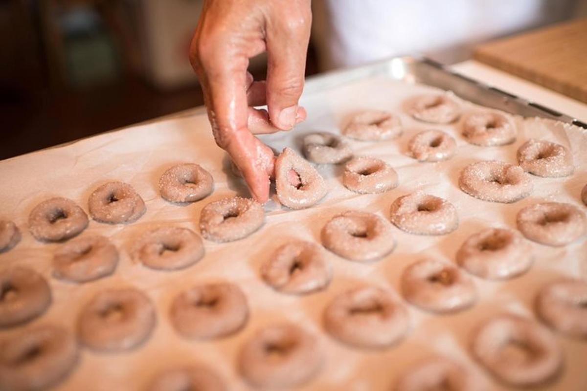 een persoon pakt een stapel donuts op een dienblad
