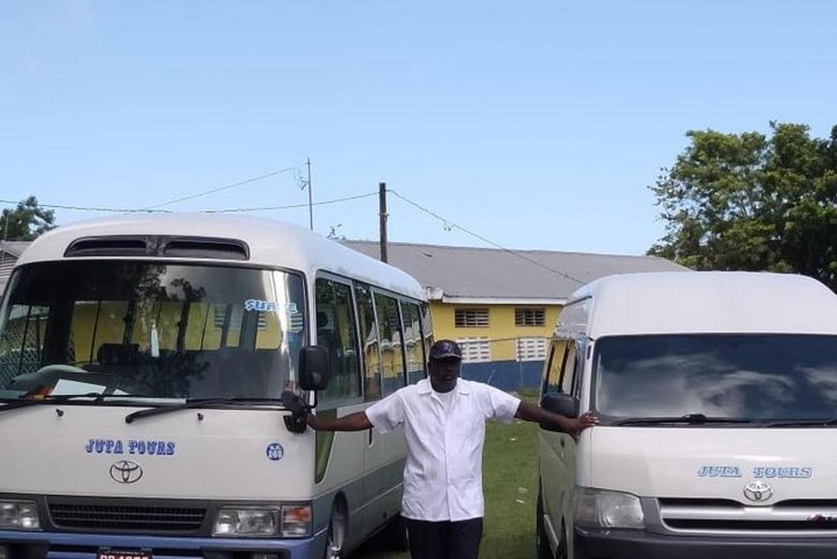 a man standing next to a bus and a truck