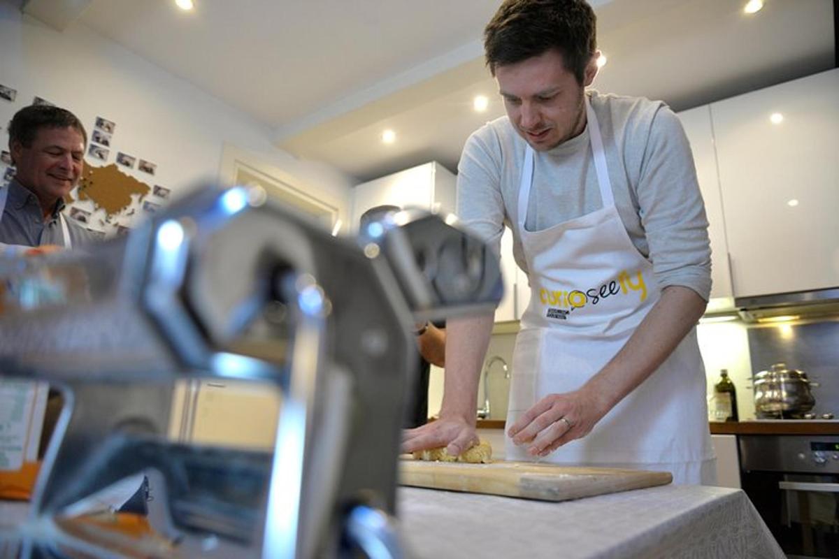 en mann på kjøkkenet som lager pizza