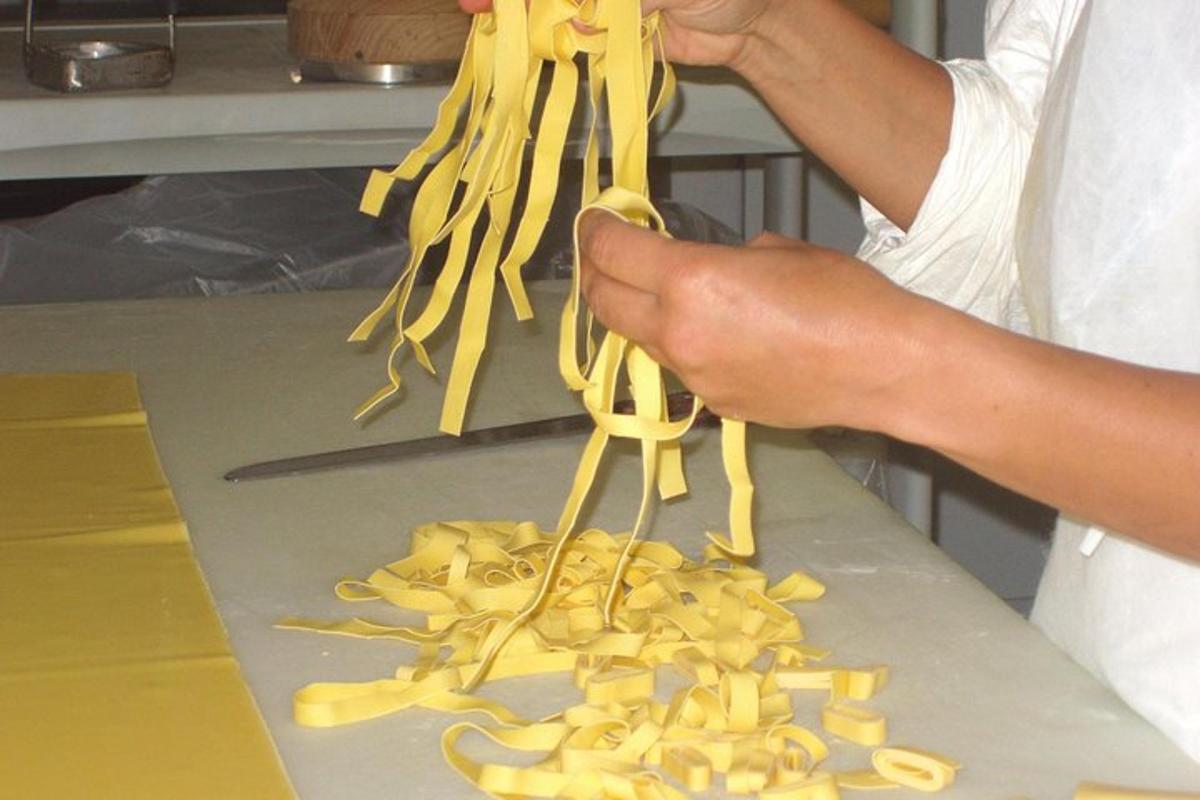 a person holding up a pile of pasta