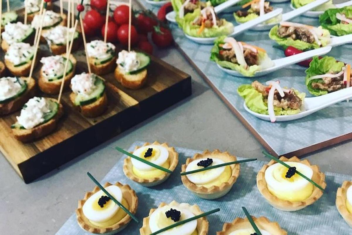 a table topped with appetizers and plates of food