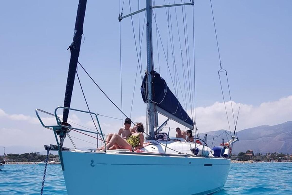 a group of people sitting on a sailboat in the water
