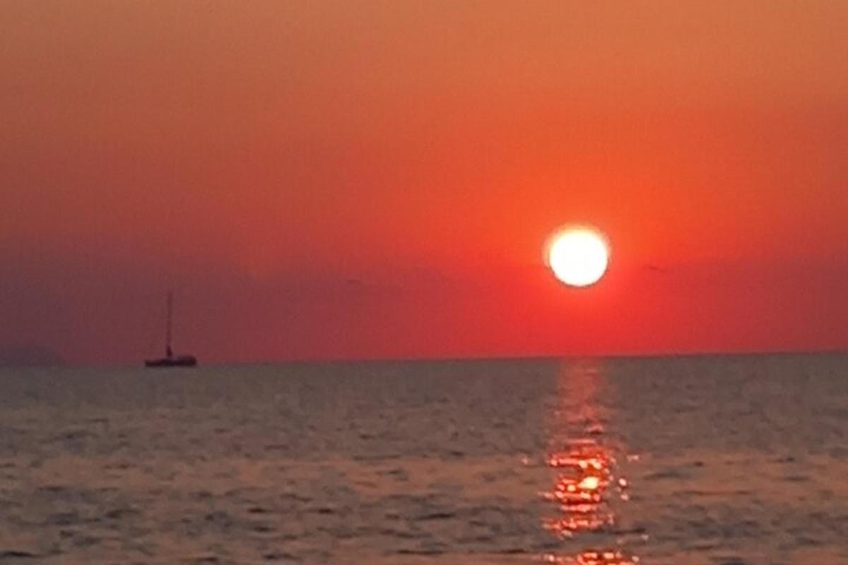 en solnedgang over havet med en båt i vannet