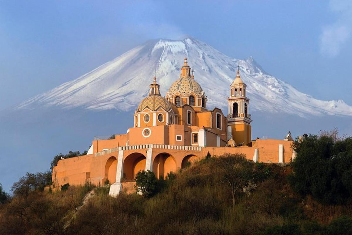 a building on a hill with a mountain in the background