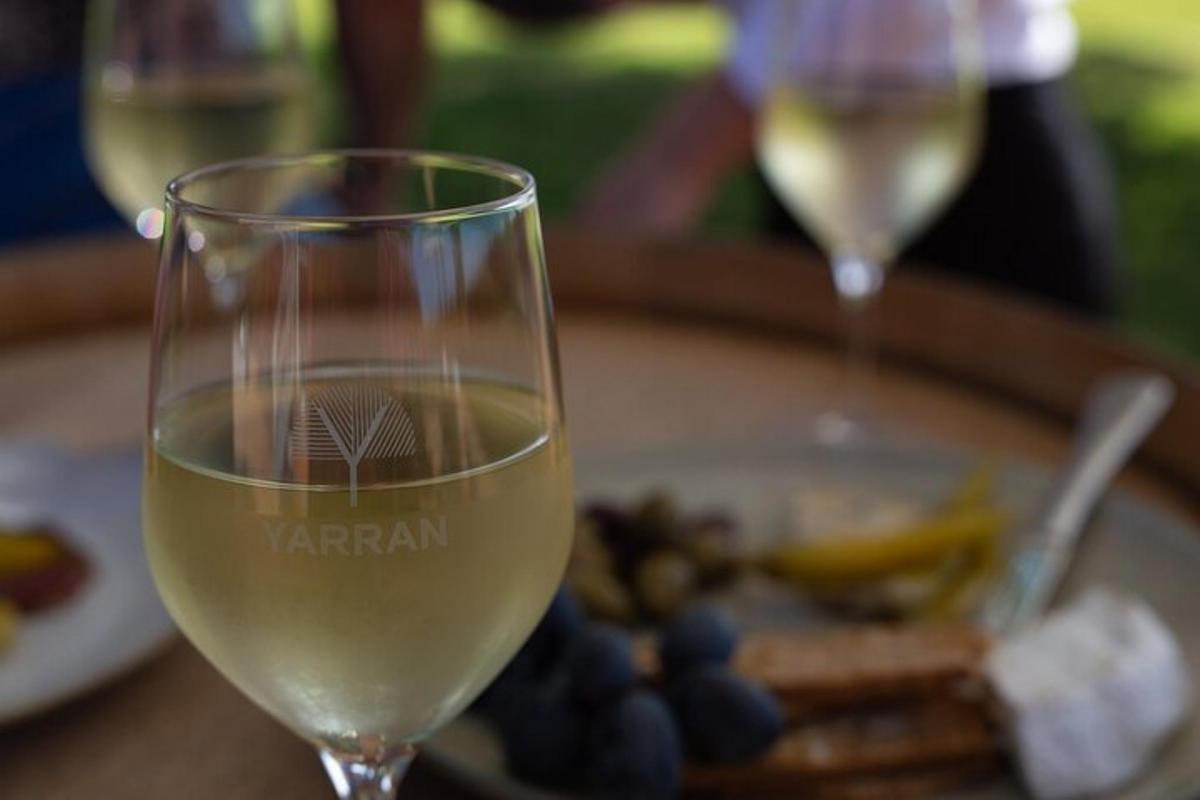 a glass of wine on a table with a plate of food