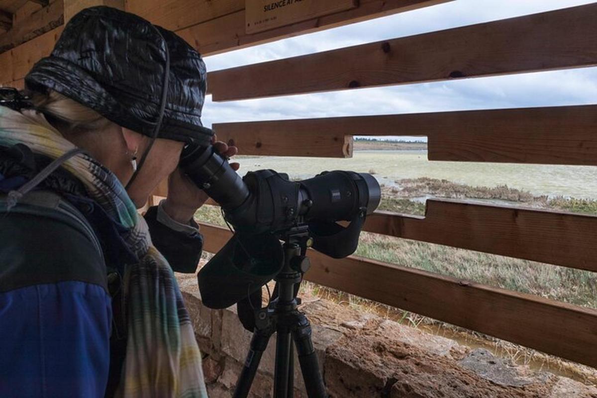 una donna con una macchina fotografica davanti a una recinzione