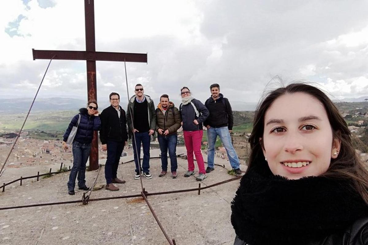 un gruppo di persone in piedi in cima a una croce