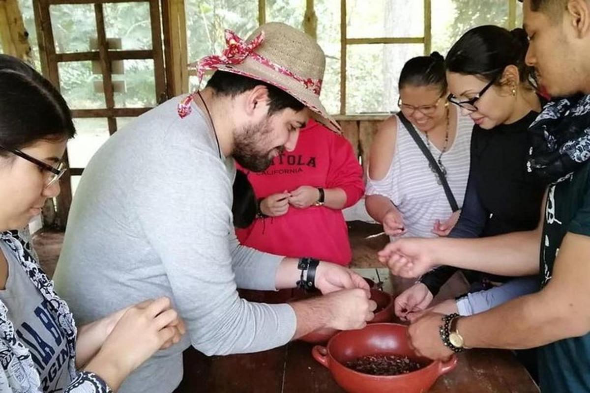 a group of people standing around a man preparing food