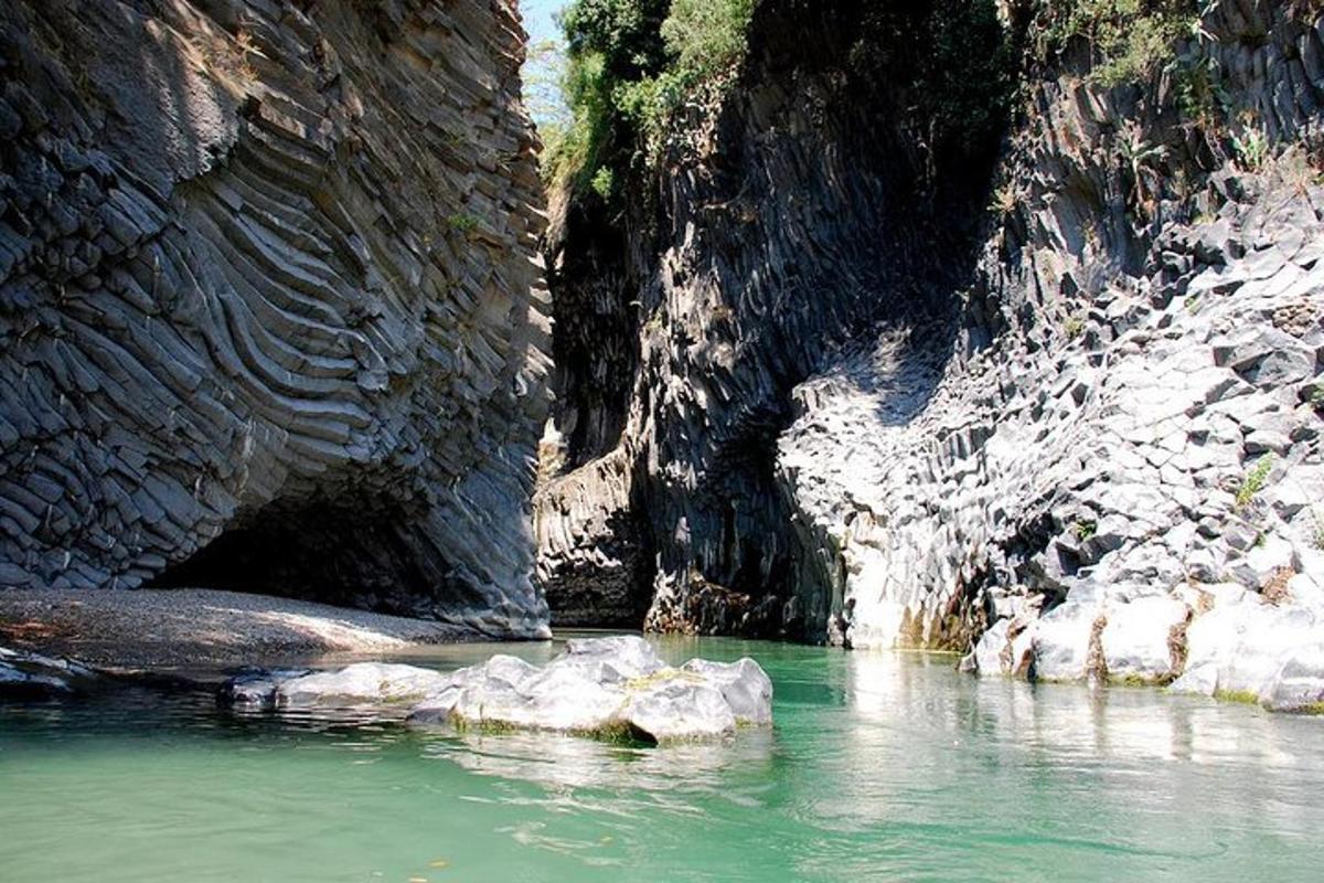una pozza d'acqua accanto a una montagna rocciosa