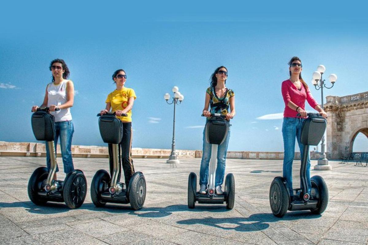 a group of women riding segways on a pier