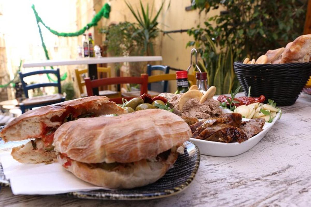 a table with a sandwich and a bowl of food