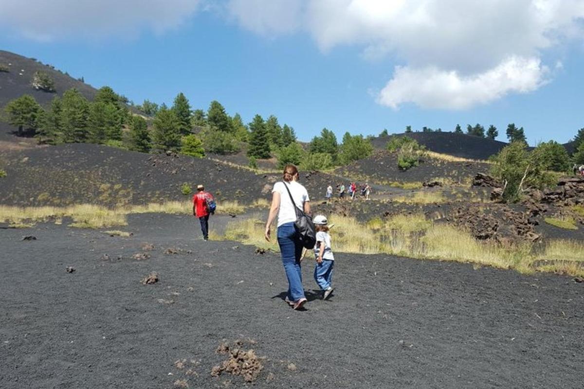 a woman and a child walking down a dirt road