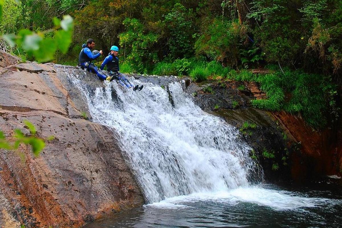 two people sitting on top of a waterfall
