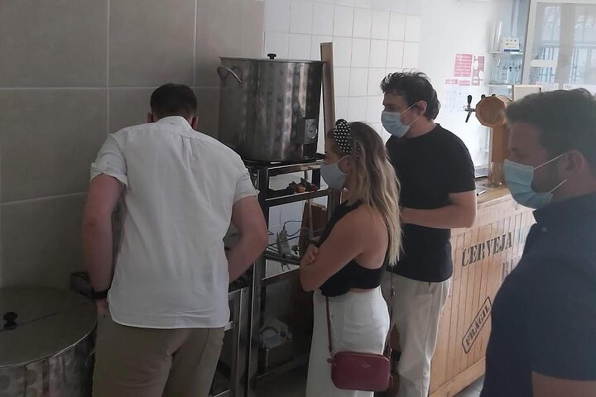 grupė žmonių, stovinčių virtuvėje su kaukėmis