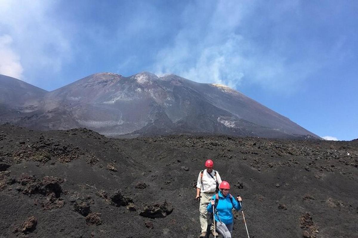 dua orang berjalan di gunung dengan gunung di latar belakang