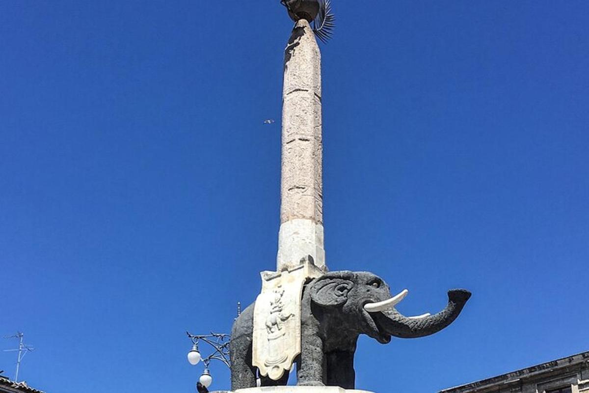 a statue of an elephant with its trunk on a pole