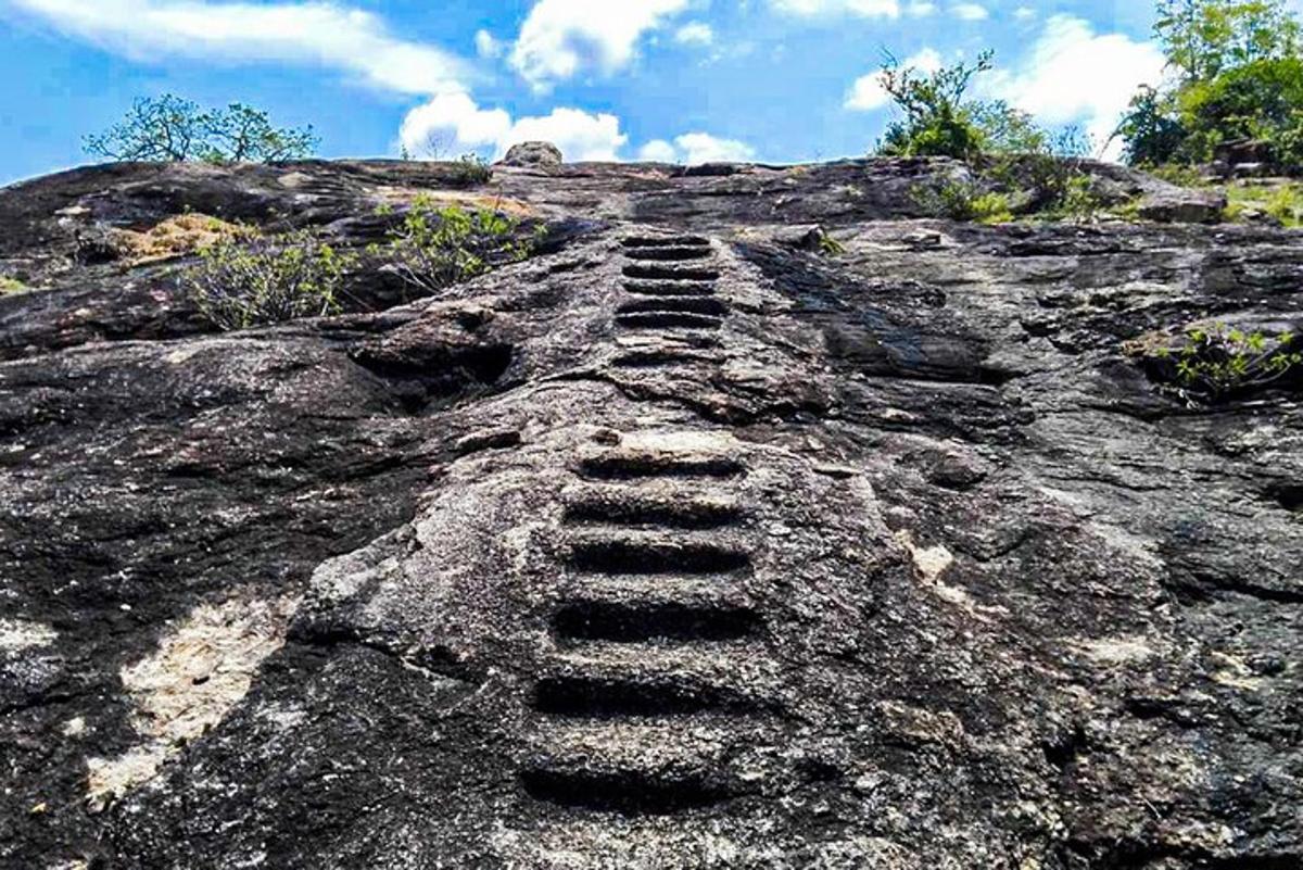 una escala a sobre d'una gran roca