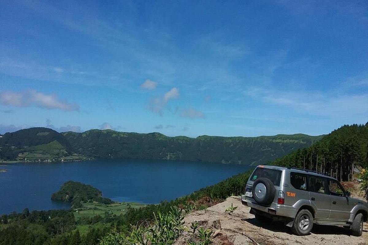 una jeep parcheggiata su una roccia vicino a un lago