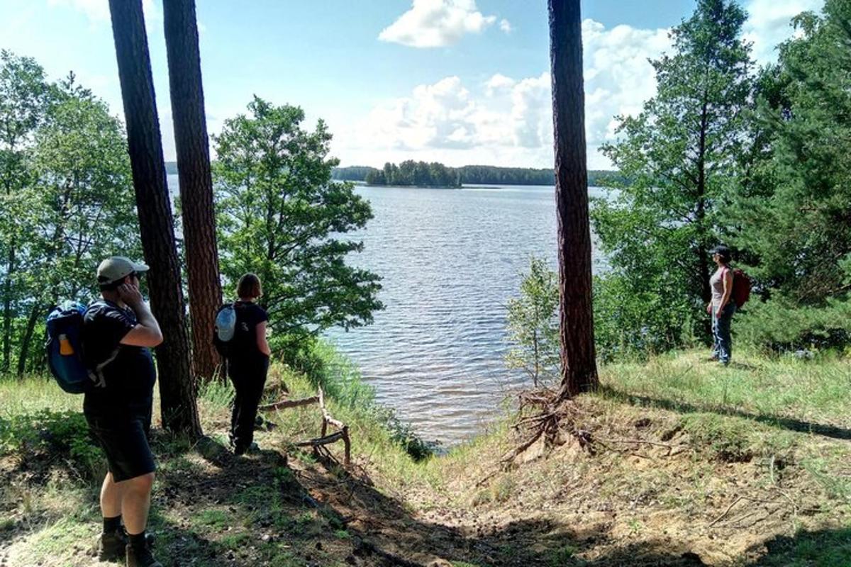 a group of people standing next to a body of water