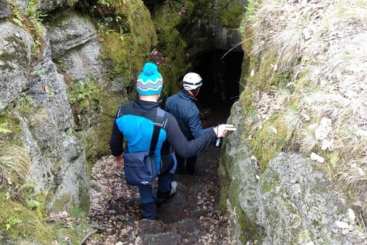 duas pessoas entrando em uma caverna escura
