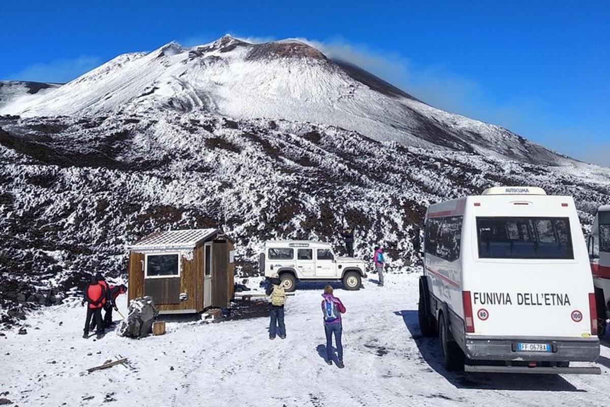 um ônibus estacionado na neve ao lado de uma montanha