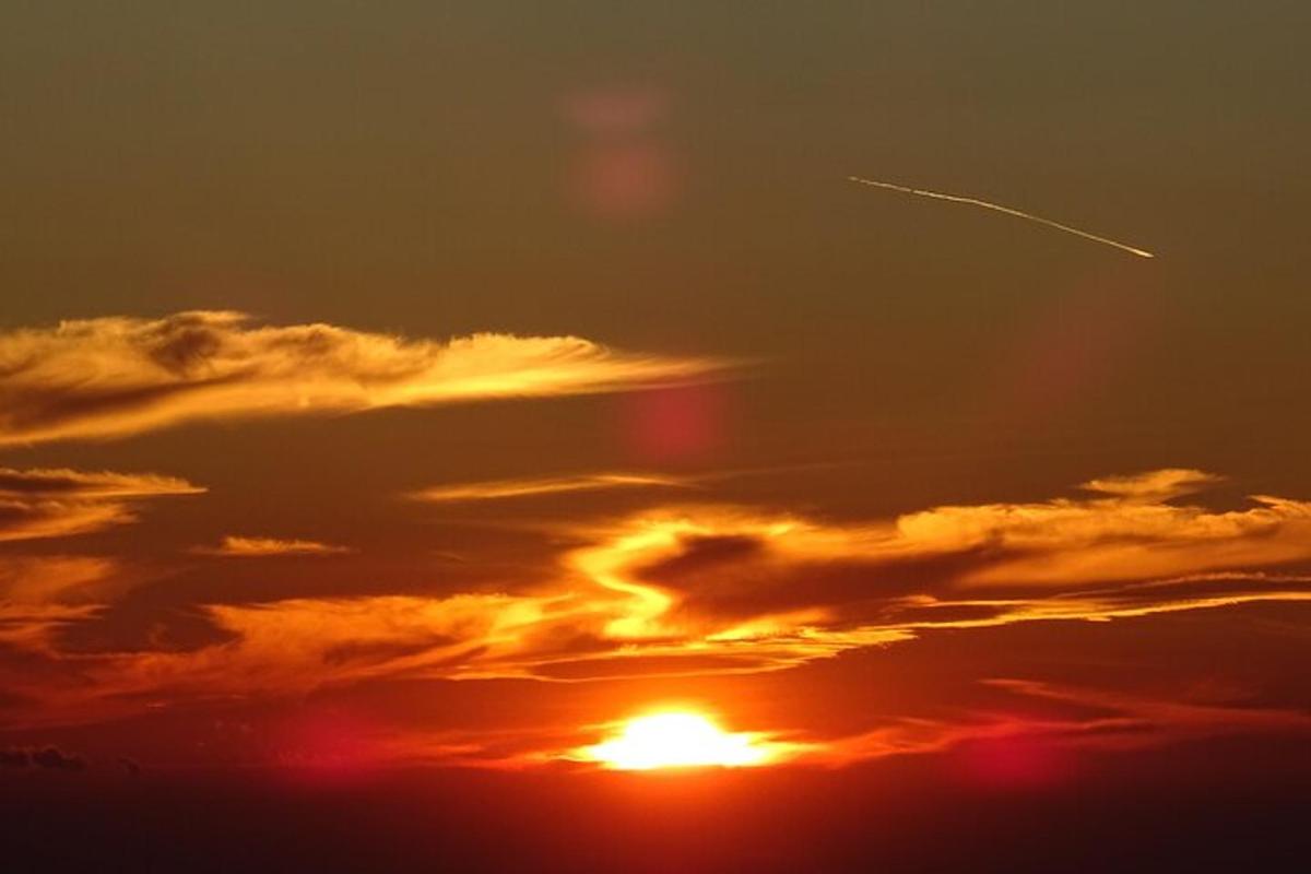 un tramonto con un aereo nel cielo