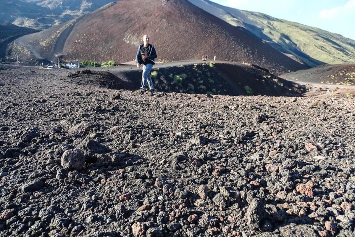 maður stendur á toppi grýtts fjalls