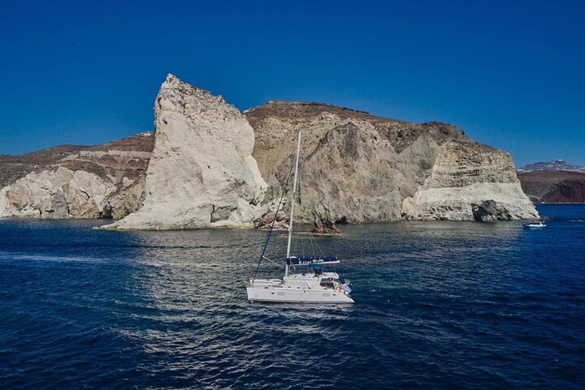 a boat in the water next to a rock formation