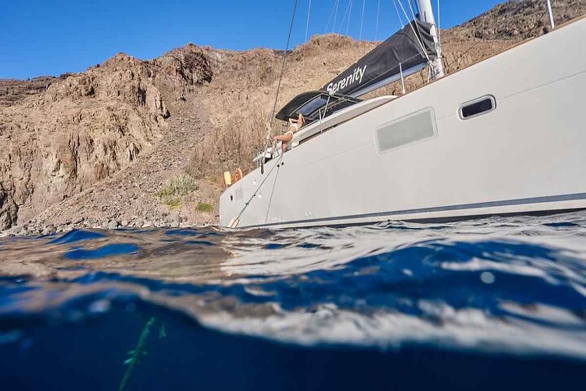 un uomo seduto su una barca a vela in acqua