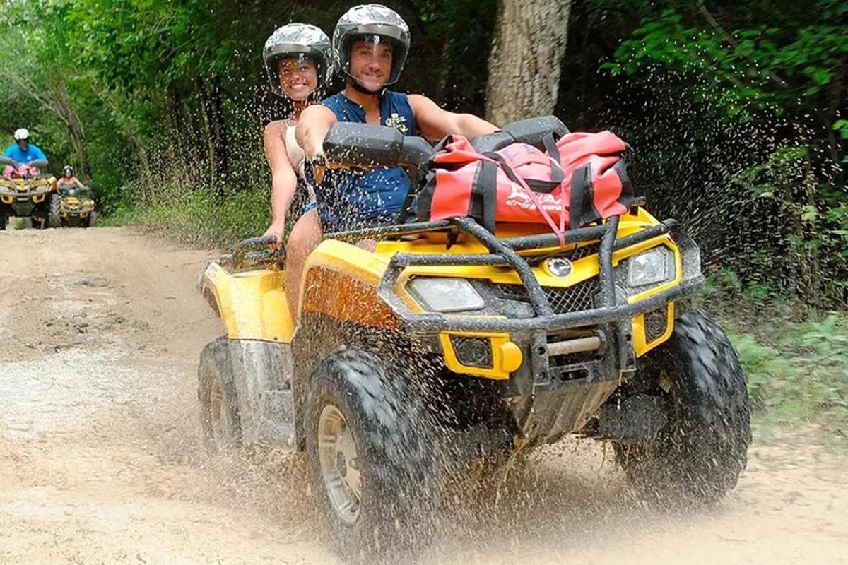 two people riding on a four wheeler in the dirt