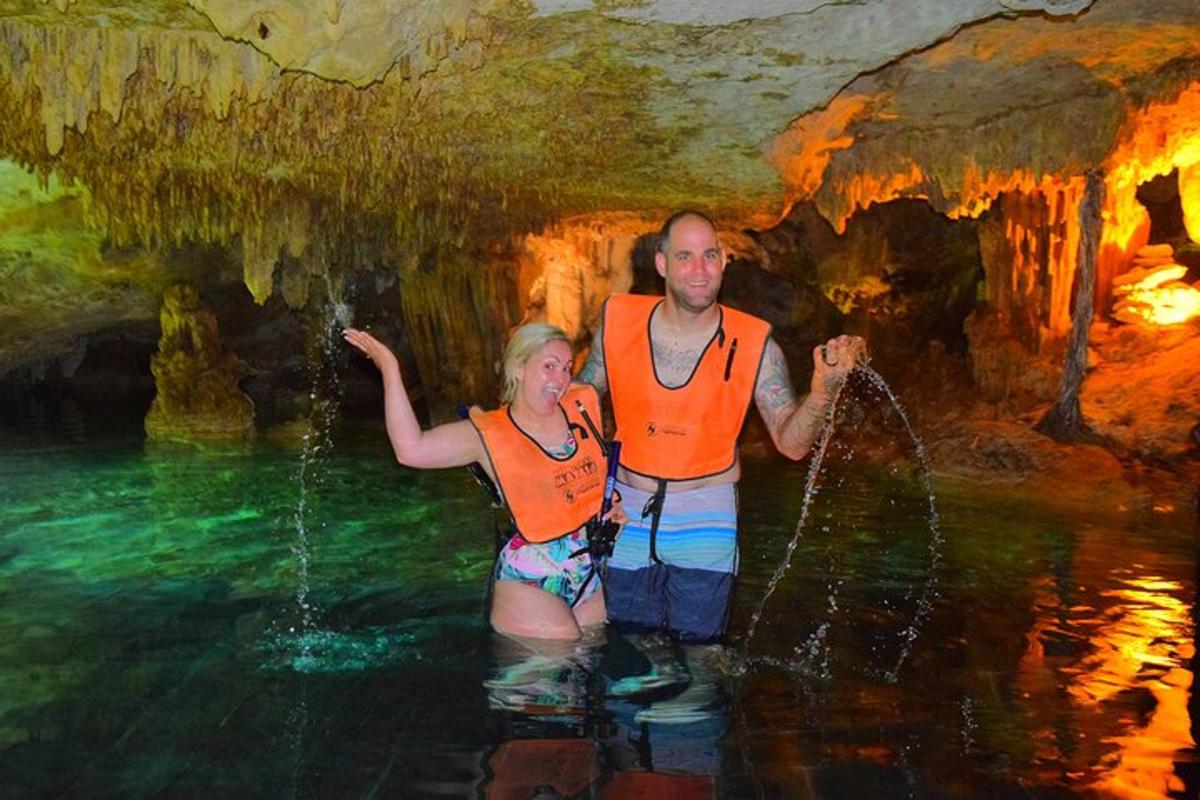 a man and woman standing in water in a cave