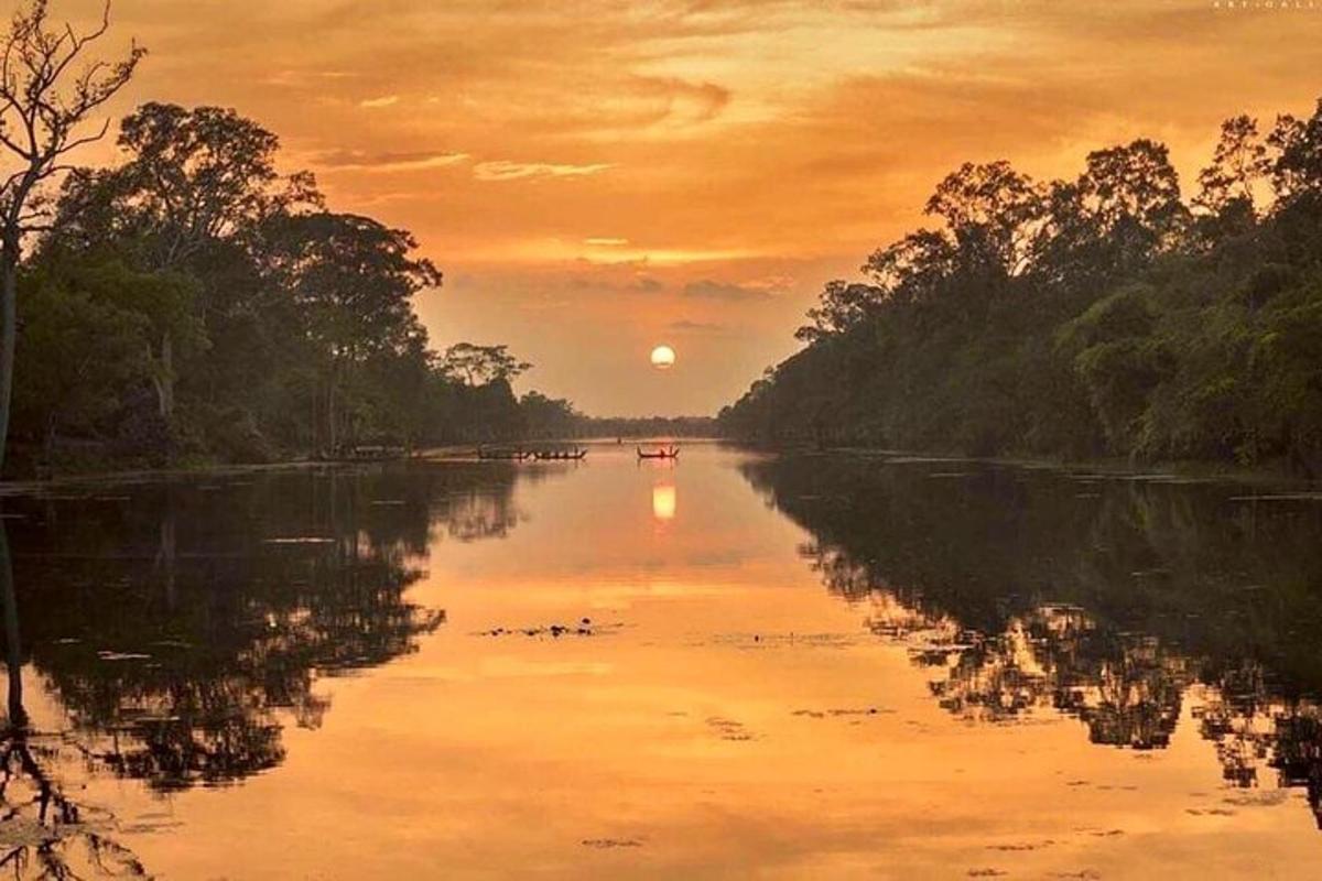 um pôr do sol em um rio com um barco nele